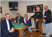 Group of Men Sitting and Standing Around the Table