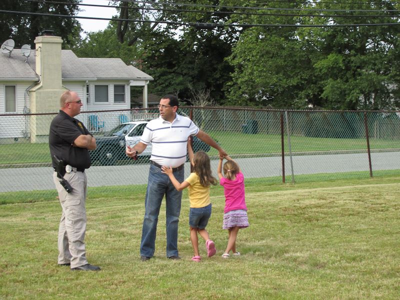 Man and His Children Speaking with Police Officer