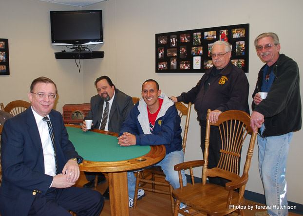 Group of Men Sitting and Standing Around the Table